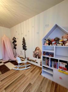 a childs room with a book shelf and a chair at HAFCIK Apartamenty przyjazne dzieciom in Poronin