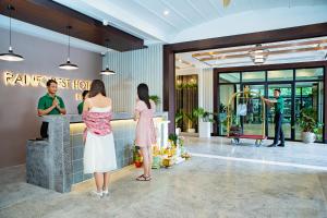 un hall d'hôtel avec des personnes debout au comptoir dans l'établissement Rainforest Hotel by NSUN, à Kampot