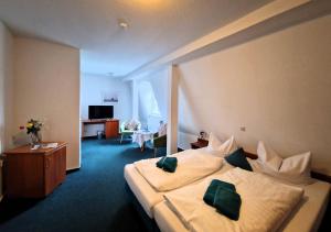 een hotelkamer met een bed met groene kussens bij Hotel Fährhaus Niederkleveez in Bösdorf