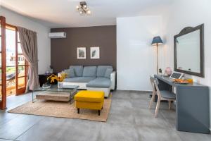 a living room with a blue couch and a table at Kos Infinity Suites in Kos Town +48 photos