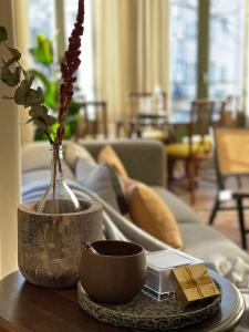 Stunning apartment by MAS في أنتويرب: غرفة معيشة مع طاولة مع مزهرية وأريكة