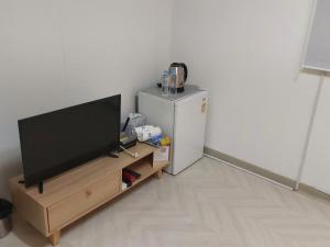 a living room with a television and a small refrigerator at Mokhwajang Motel in Goyang