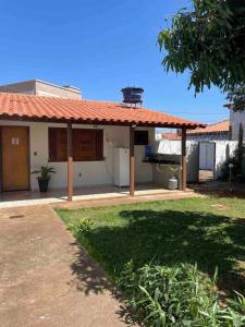una casa con techo naranja y patio en Suíte c/ar e varanda perto do Parque de Exposições, en Patos de Minas