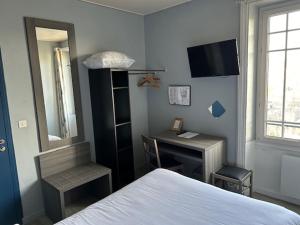 1 dormitorio con cama, escritorio y espejo en Hôtel de la Poste - Piriac-sur-mer, en Piriac-sur-Mer