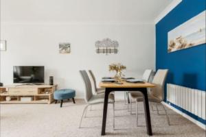 a dining room with a table and chairs and a tv at Oak Lodge in Poole