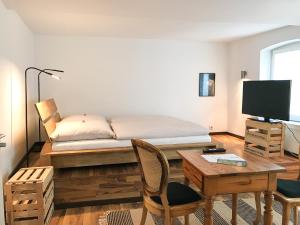 a bedroom with a bed and a desk and a table with a desk at Fuxbau in Neustadt an der Weinstraße