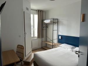 1 dormitorio con cama, escritorio y estante en Hôtel de la Poste - Piriac-sur-mer, en Piriac-sur-Mer