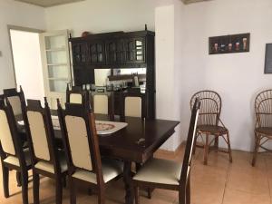 uma sala de jantar com uma mesa preta e cadeiras em La casa de la abuela em Rivera