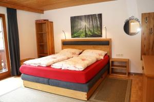 um quarto com uma cama com um colchão vermelho em Birkenheim em Sankt Leonhard im Pitztal