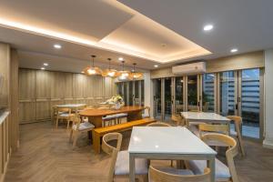 un restaurante con mesas, sillas y ventanas en Aonang All Seasons Beach Resort en Ao Nang Beach