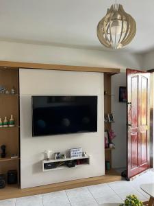 a living room with a flat screen tv on a wall at Casa em Praia Seca, Araruama. in Araruama