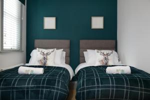 two beds in a room with green walls at The Old Brewery Boardroom - Winchester City Centre, Free Parking for 2 Cars, Sleeps 6 in Winchester