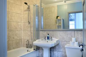 a bathroom with a sink and a tub and a toilet at The Old Brewery Boardroom - Winchester City Centre, Free Parking for 2 Cars, Sleeps 6 in Winchester