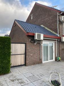 een stenen huis met een garage met een ventilator bij Hotelkamer Bellevue in Simpelveld