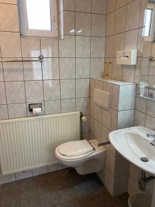 a bathroom with a toilet and a sink at Hotelkamer Bellevue in Simpelveld