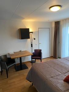 a hotel room with a desk and a bed at Hotelkamer Bellevue in Simpelveld