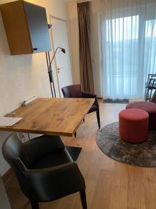 a living room with a table and a chair at Hotelkamer Bellevue in Simpelveld