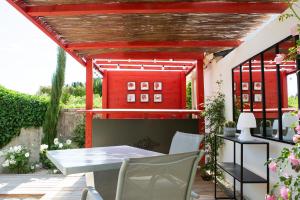 a patio with a table and chairs and a red building at L’annexe in Orange