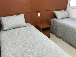 1 dormitorio con 2 camas y mesita de noche en Apartamento 2Q Próximo ao Hospital Premium NW1306, en Goiânia