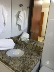 y baño con lavabo y espejo. en Apartamento 2Q Próximo ao Hospital Premium NW1306, en Goiânia