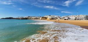 a view of a beach with buildings in the background at Velha 34 in Albufeira