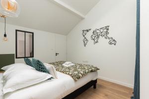 una camera da letto con pareti bianche e un letto di DIFY Loft de Noailles - Villeurbanne a Villeurbanne