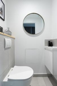 bagno bianco con servizi igienici e specchio di DIFY Loft de Noailles - Villeurbanne a Villeurbanne