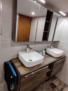 a bathroom with two sinks and a mirror at Engelberg, Renovated Chalet in Wonderful Location in Engelberg