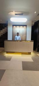 a man standing behind a counter in a building at Hotel Madhavam- 250 Mtr from Mathura Railway Station in Mathura