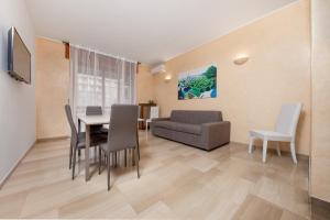ein Wohnzimmer mit einem Tisch, Stühlen und einem Sofa in der Unterkunft Casa da Suite Superba in Mailand