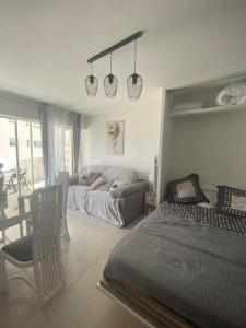 un soggiorno con un letto e un divano di Magnifique studio au pied des plages a Cannes