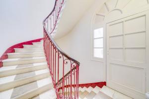 uma escada com uma parede vermelha e branca e uma porta em Charming apartment in the heart of Bordeaux em Bordeaux
