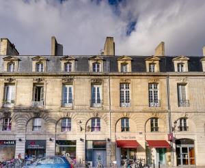 um grande edifício com carros estacionados em frente em Charming apartment in the heart of Bordeaux em Bordeaux