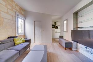 a living room with a couch and a large television at Charming apartment in the heart of Bordeaux in Bordeaux