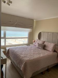 科金博的住宿－Confortable Dpto. en Playa la Herradura，一间卧室设有一张大床和大窗户