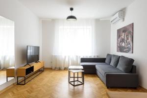 ein Wohnzimmer mit einem Sofa und einem TV in der Unterkunft Tim 3 in Belgrad