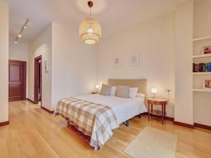 a bedroom with a large white bed and a table at Apartamento El Cuarto Rey by Clabao in Pamplona
