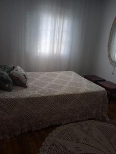 ein Schlafzimmer mit einem Bett mit einer weißen Bettdecke in der Unterkunft Simples e confortável in Londrina