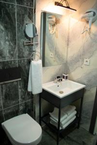 een badkamer met een wastafel, een toilet en een spiegel bij Lagom Hotel in Edirne