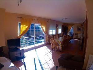 sala de estar con sofá y comedor en Villa Pilara en Brunete