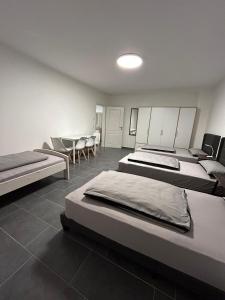 Habitación con 3 camas, mesa y sillas en Pension Imhof, en Oyten
