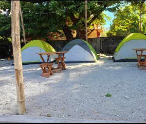 een groep tenten en picknicktafels aan de voorkant bij Camp Binoclutan Kubotel in Botolan