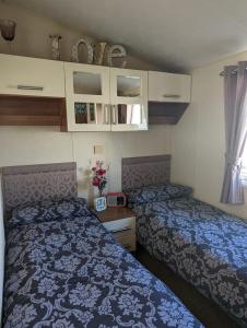 a small bedroom with two beds and a window at Lovely and Bright Caravan Haven Littlesea with views across the Fleet Lagoon in Weymouth
