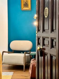 une chambre bleue avec une chaise et une porte avec une chaise et une chaise dans l'établissement Cozy Beautiful flat City Center, à Madrid