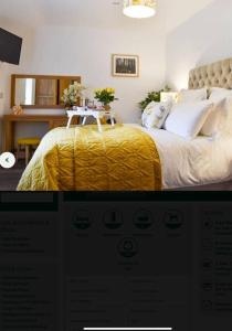 1 dormitorio con 1 cama con manta amarilla en Thistle cottage 5 star luxury cottage with Hot Tub, en Scarborough