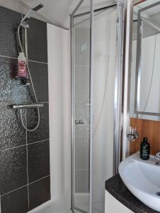 a bathroom with a shower and a sink at Lovely and Bright Caravan Haven Littlesea with views across the Fleet Lagoon in Weymouth