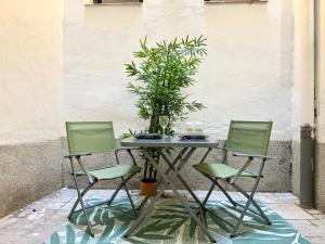 une table avec trois chaises et une plante en pot dans l'établissement Cozy Beautiful flat City Center, à Madrid