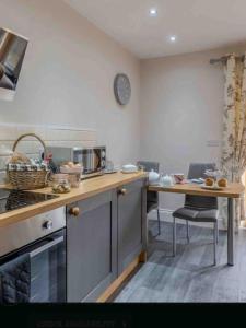 cocina con encimera y mesa con reloj en la pared en Thistle cottage 5 star luxury cottage with Hot Tub, en Scarborough