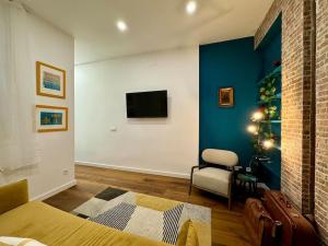 Cette chambre comprend un lit, une chaise et une télévision. dans l'établissement Cozy Beautiful flat City Center, à Madrid