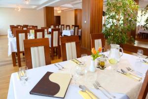 Hotel Arman في Nižná: غرفة طعام مع طاولة مع قطعة قماش بيضاء